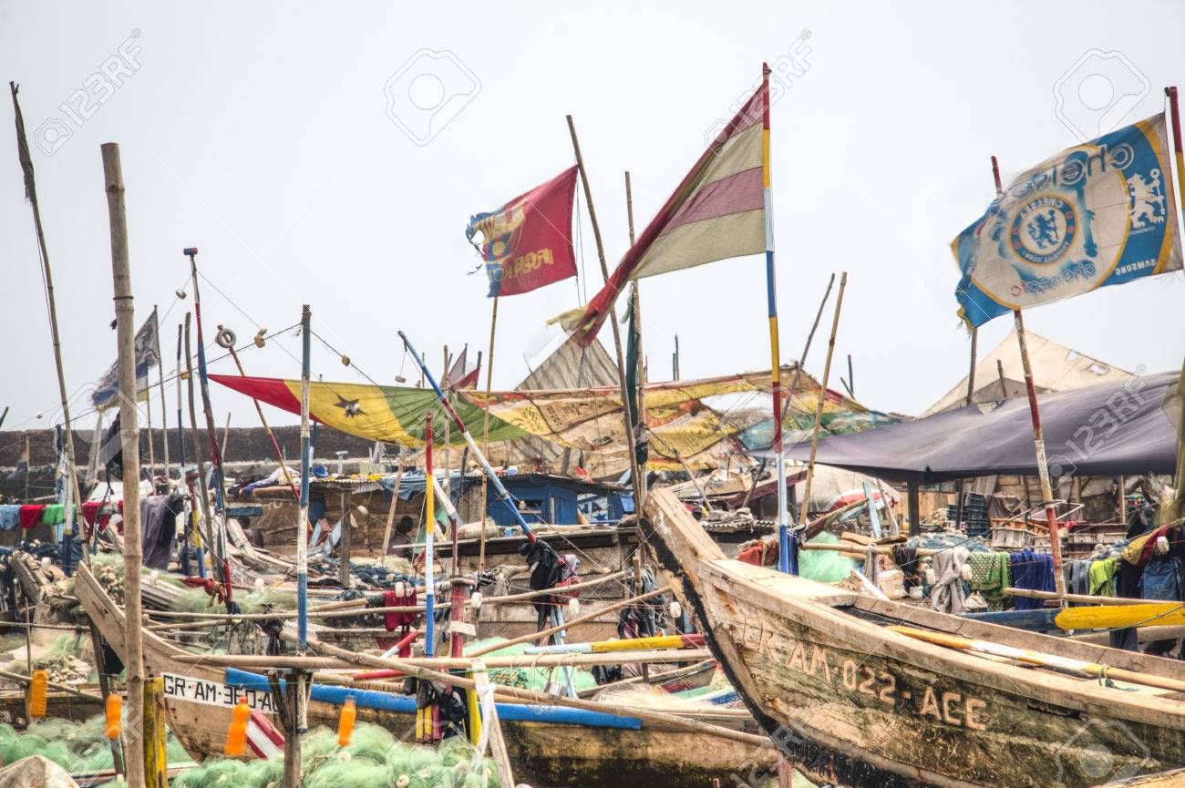 Barche da pesca colorate sulla spiaggia di Jamestown, Accra, con il faro storico sullo sfondo