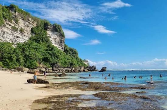 Bali Padang Padang beach in Uluwatu with a narrow sandy cove between limestone cliffs and turquoise water