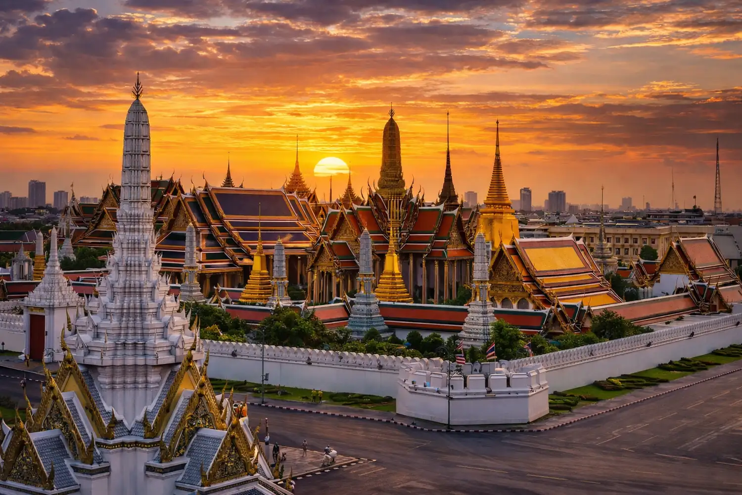 Bangkok Grand Palace complex with glittering gold spires and colourful mosaic details under a blue sky