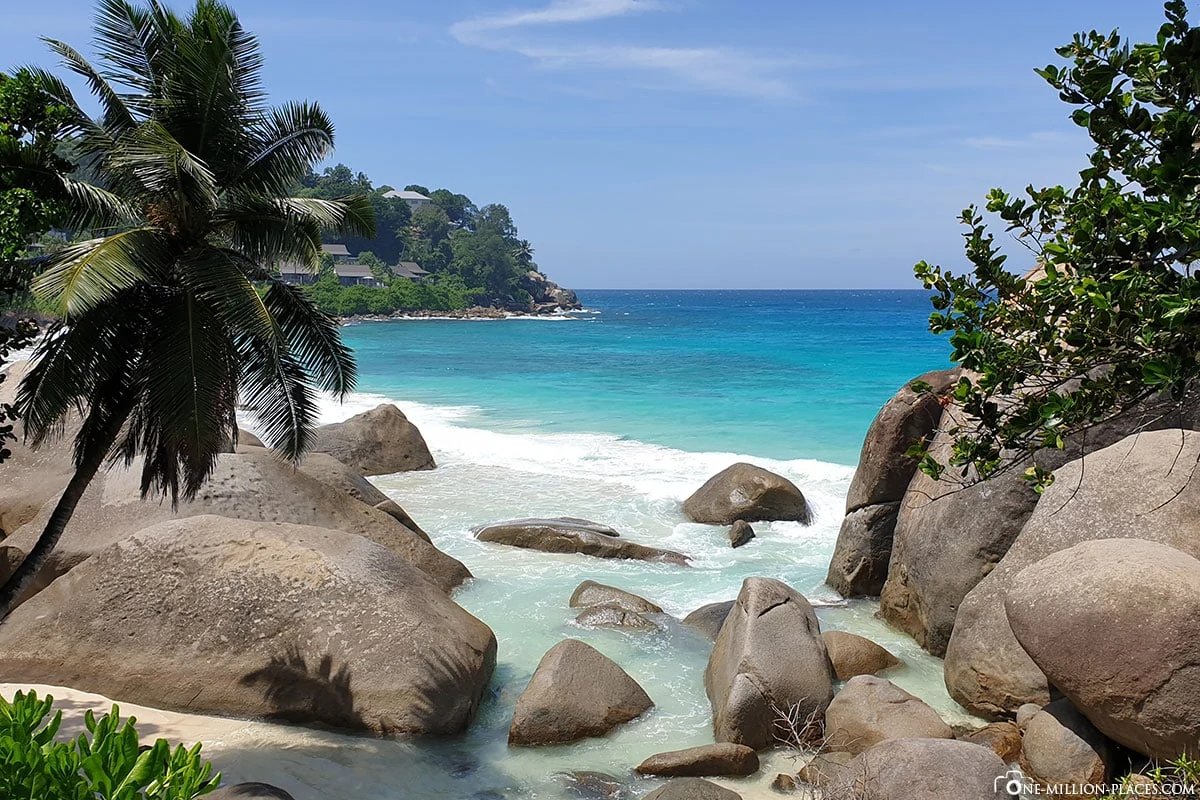 Beau Vallon Strand auf Mahe mit Granitfelsen und ruhigem türkisfarbenem Wasser zur goldenen Stunde