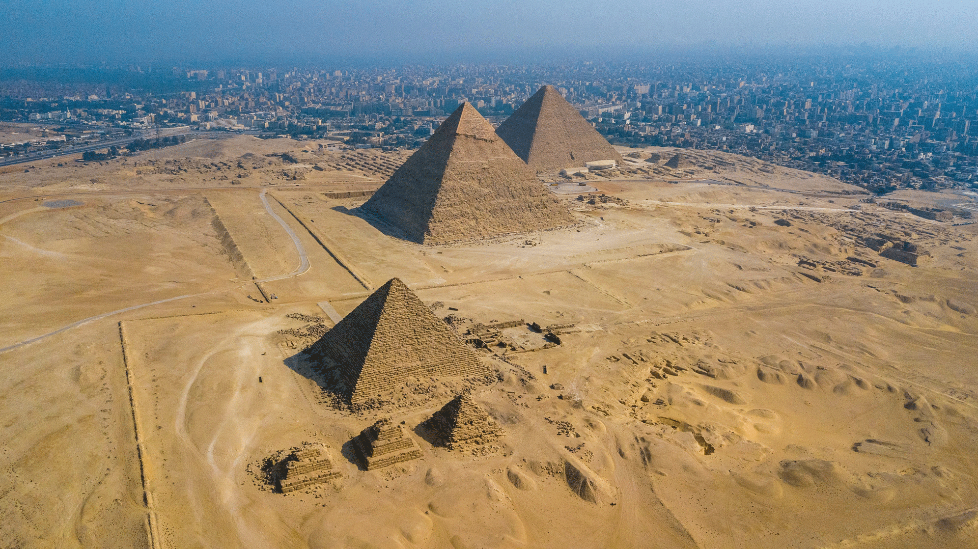 The Giza pyramids at the edge of Cairo with the city skyline in the distance