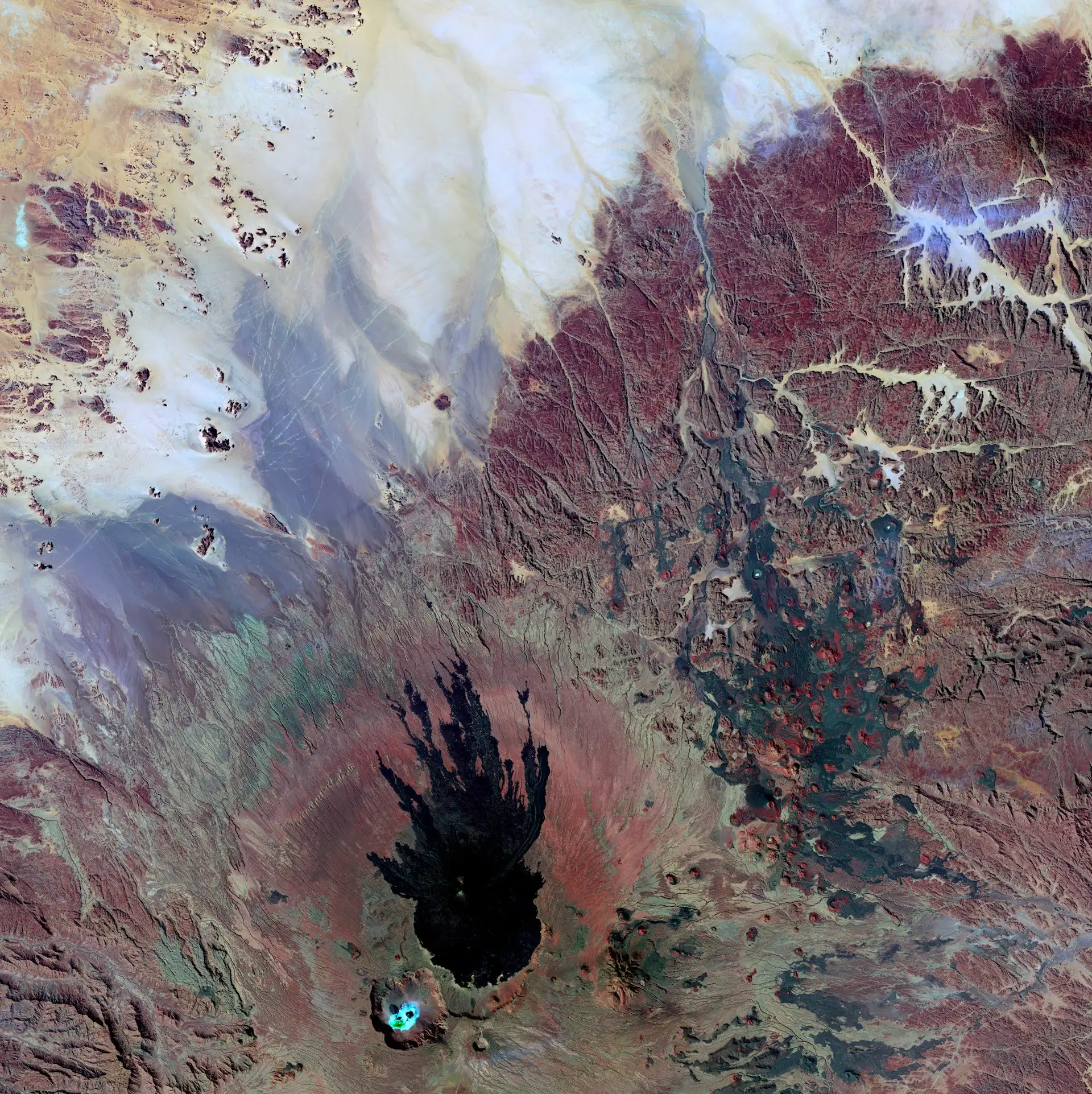 The Ennedi Plateau in northeastern Chad — sandstone arches and rock formations rising from the Saharan desert, with ancient cave paintings sheltered in the rock overhangs