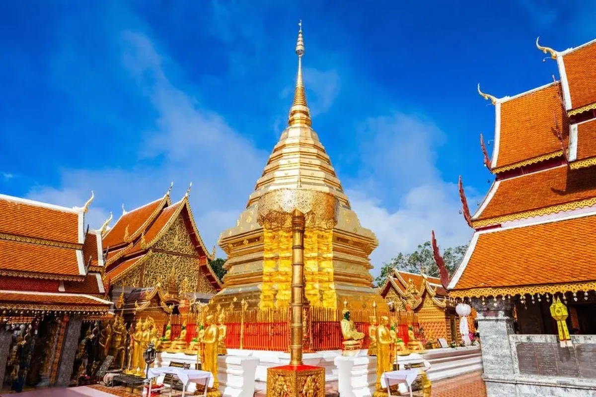 チェンマイの金色のチェディとオレンジ色の屋根の寺院堂