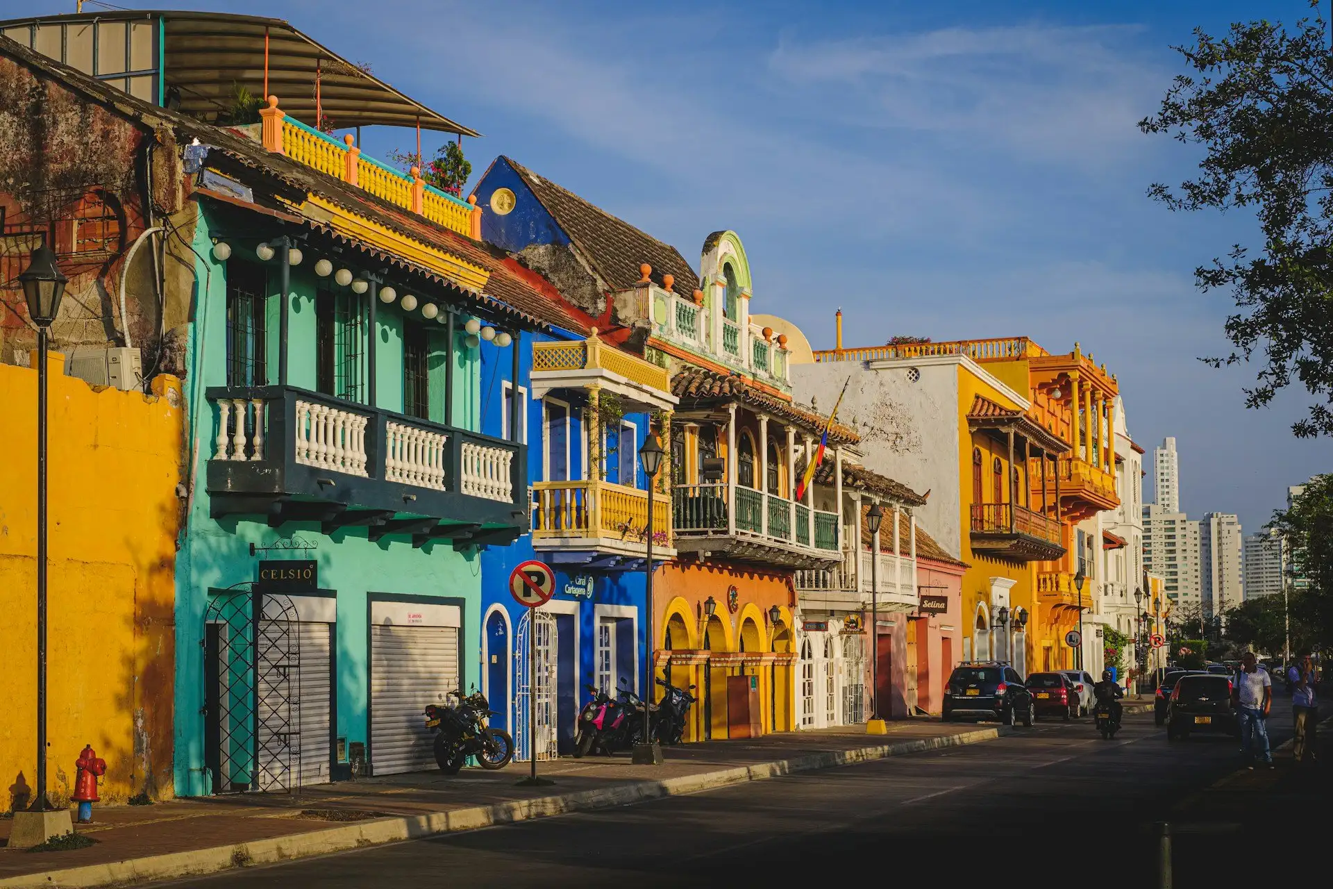 Bâtiments coloniaux colorés bordant une rue pavée dans la ville fortifiée de Carthagène avec des bougainvilliers cascadant des balcons en fer forgé, Colombie