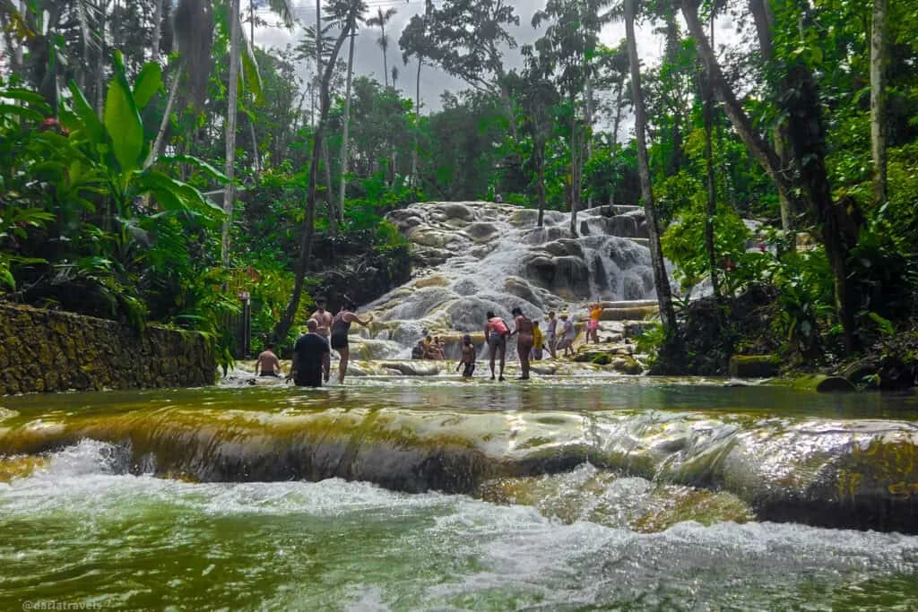 Visitatori che scalano le cascate a terrazze di Dunn's River Falls vicino a Ocho Rios, Giamaica