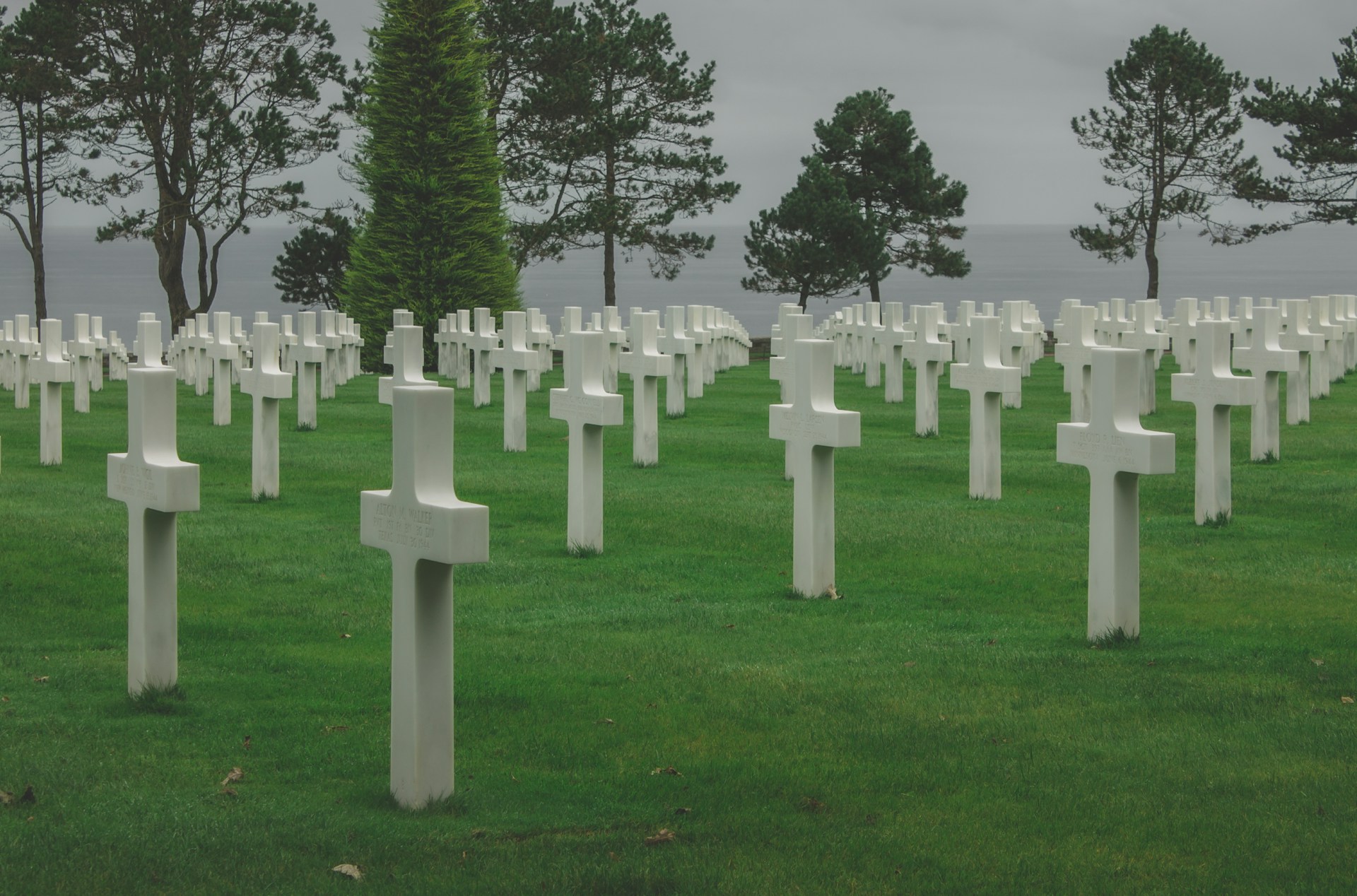Amerikanischer Friedhof in Colleville-sur-Mer oberhalb des Omaha Beach in der Normandie mit weißen Marmorkreuzen auf grünen Klippen