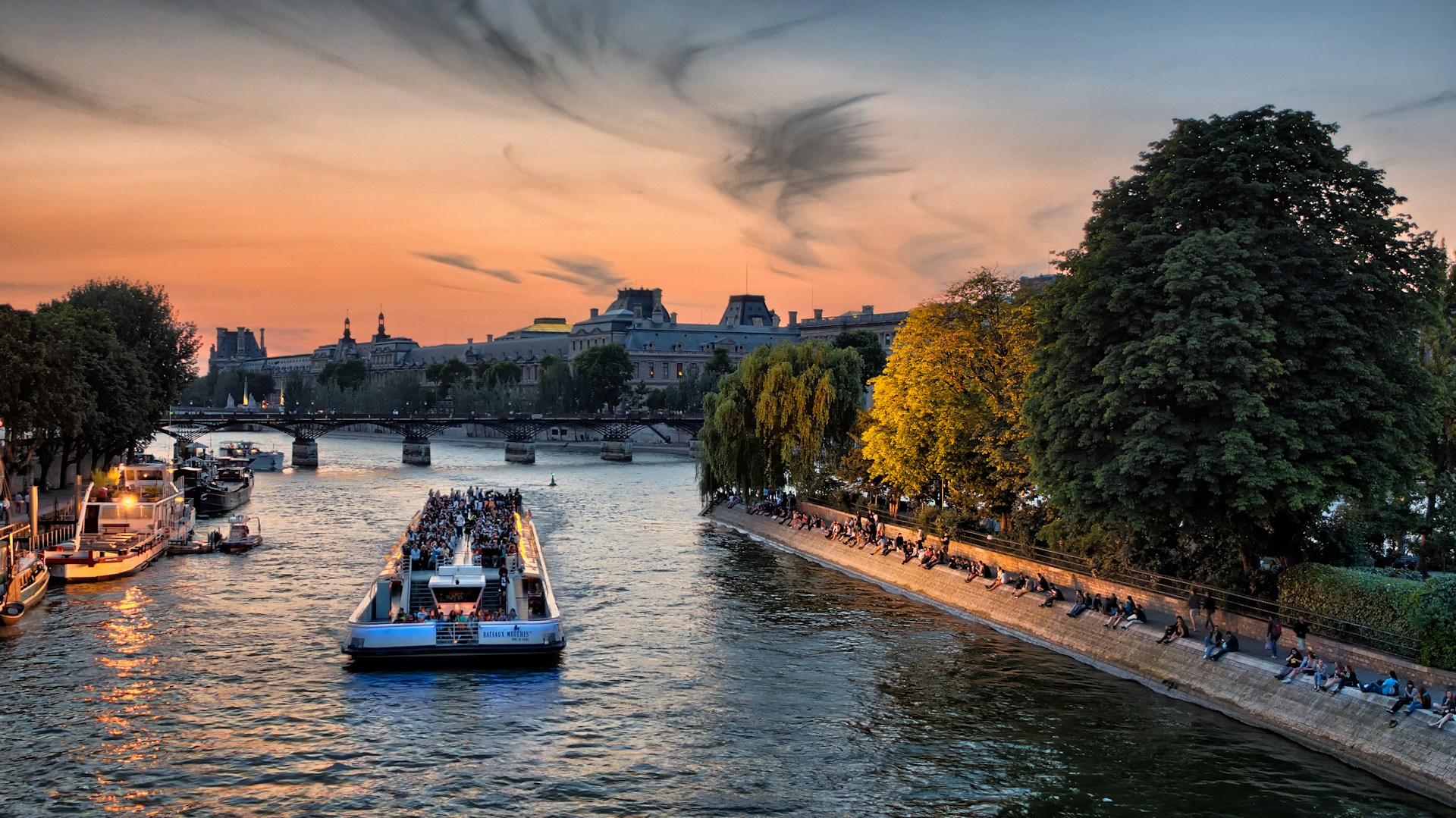 Pariser Skyline bei Dämmerung von der Seine aus mit dem Eiffelturm und goldenem Licht auf dem Wasser