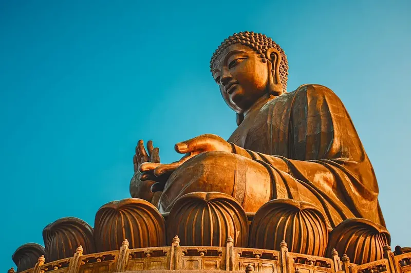 De bronzen Tian Tan Buddha op Lantau Island tegen een blauwe lucht