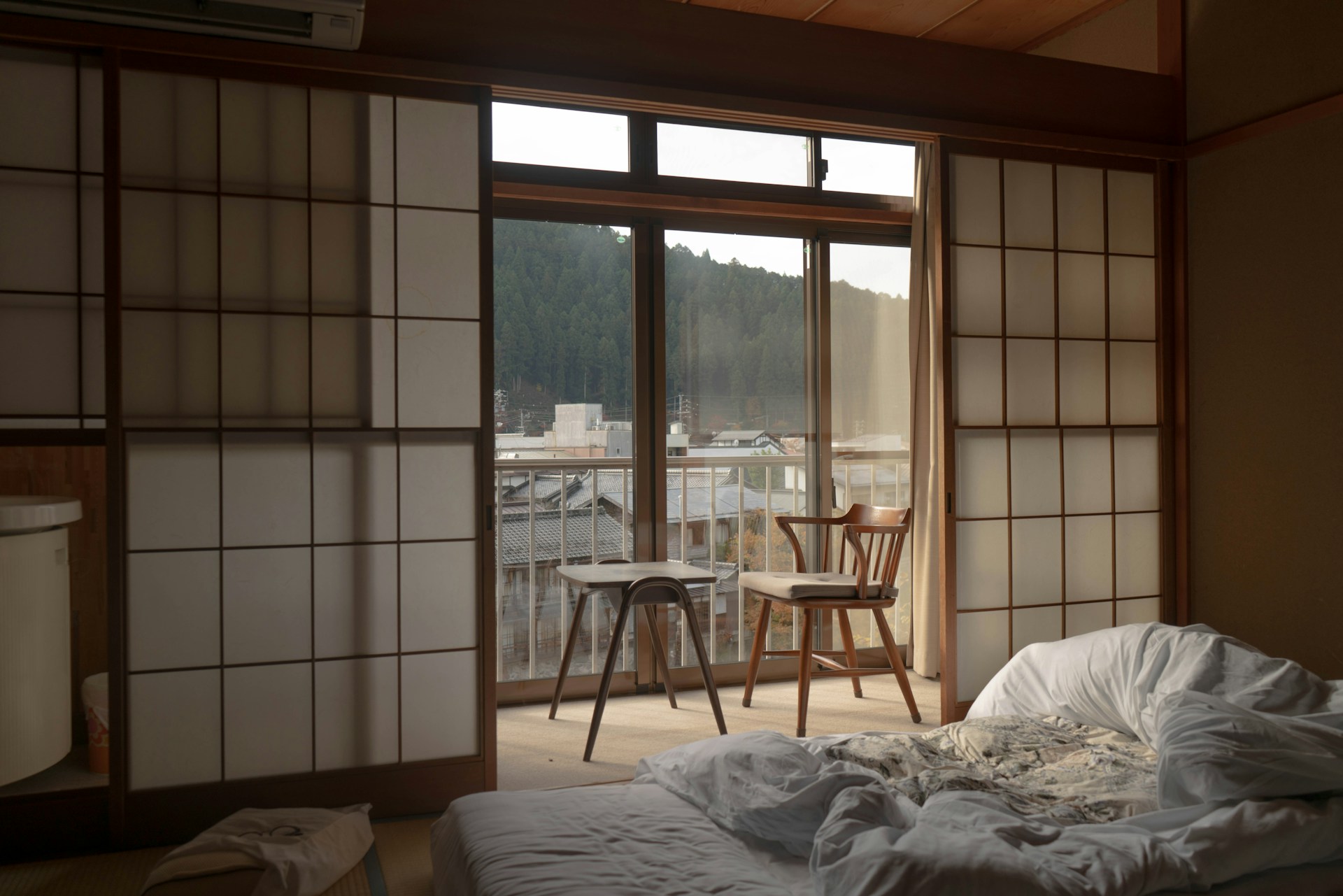 Stanza tradizionale di ryokan giapponese con pavimenti tatami, futon, porte shoji e vista sul giardino a Hakone o Kyoto