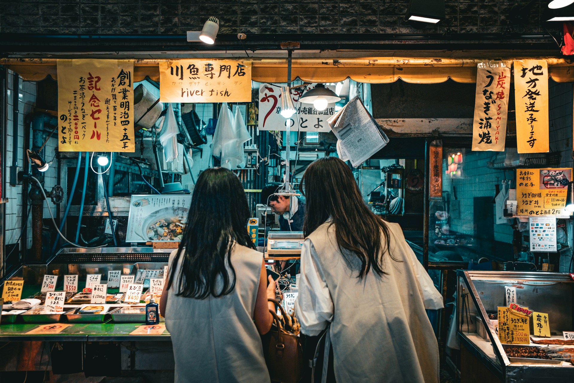 Banchi di street food giapponese ad Asakusa con taiyaki, dango e spiedini fumanti sotto lanterne rosse