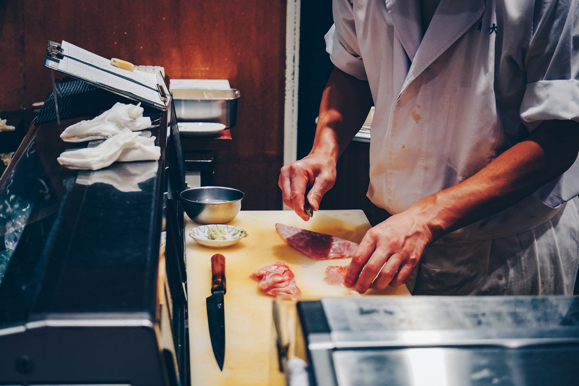 Piatto di nigiri sushi fresco con tonno, salmone, ricciola e gamberi su un bancone di sushi a Tokyo