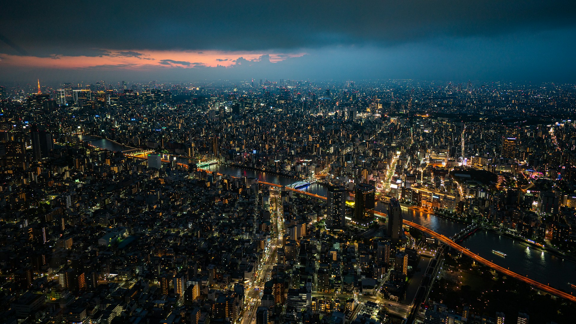 Skyline di Tokyo di notte con la Tokyo Tower illuminata e la metropoli che si estende fino all’orizzonte