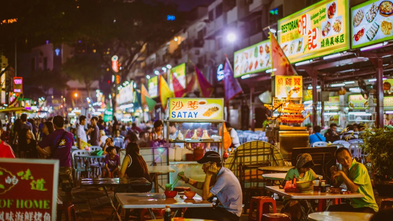 Kuala Lumpur Jalan Alor street food scene at night with hanging lanterns, grilled satay and crowded tables