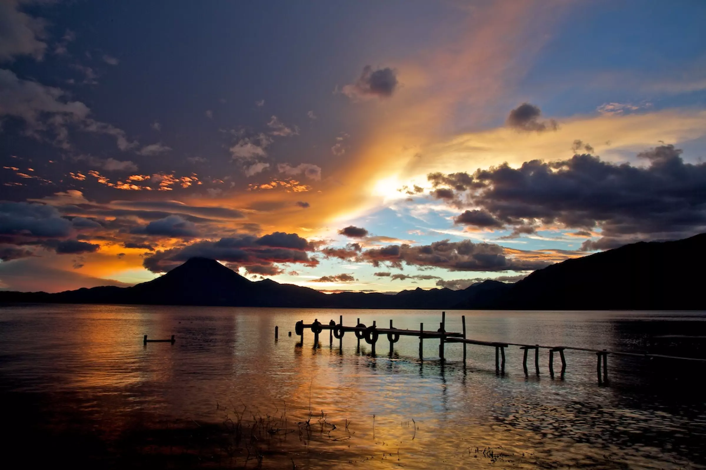 Lago Atitlan ao pôr do sol com os vulcões Toliman e Atitlan refletidos na água