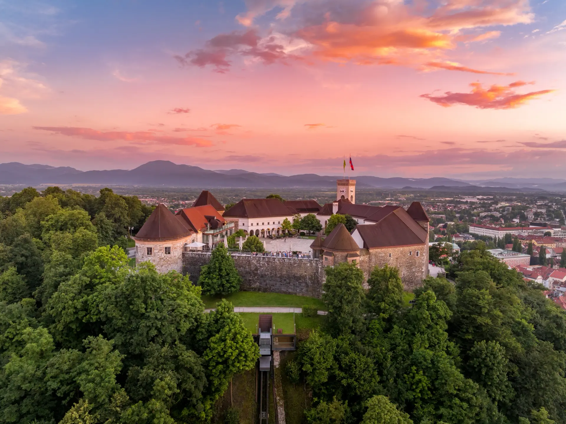 Il Castello di Lubiana sopra il fiume Ljubljanica e il centro storico senza auto al crepuscolo