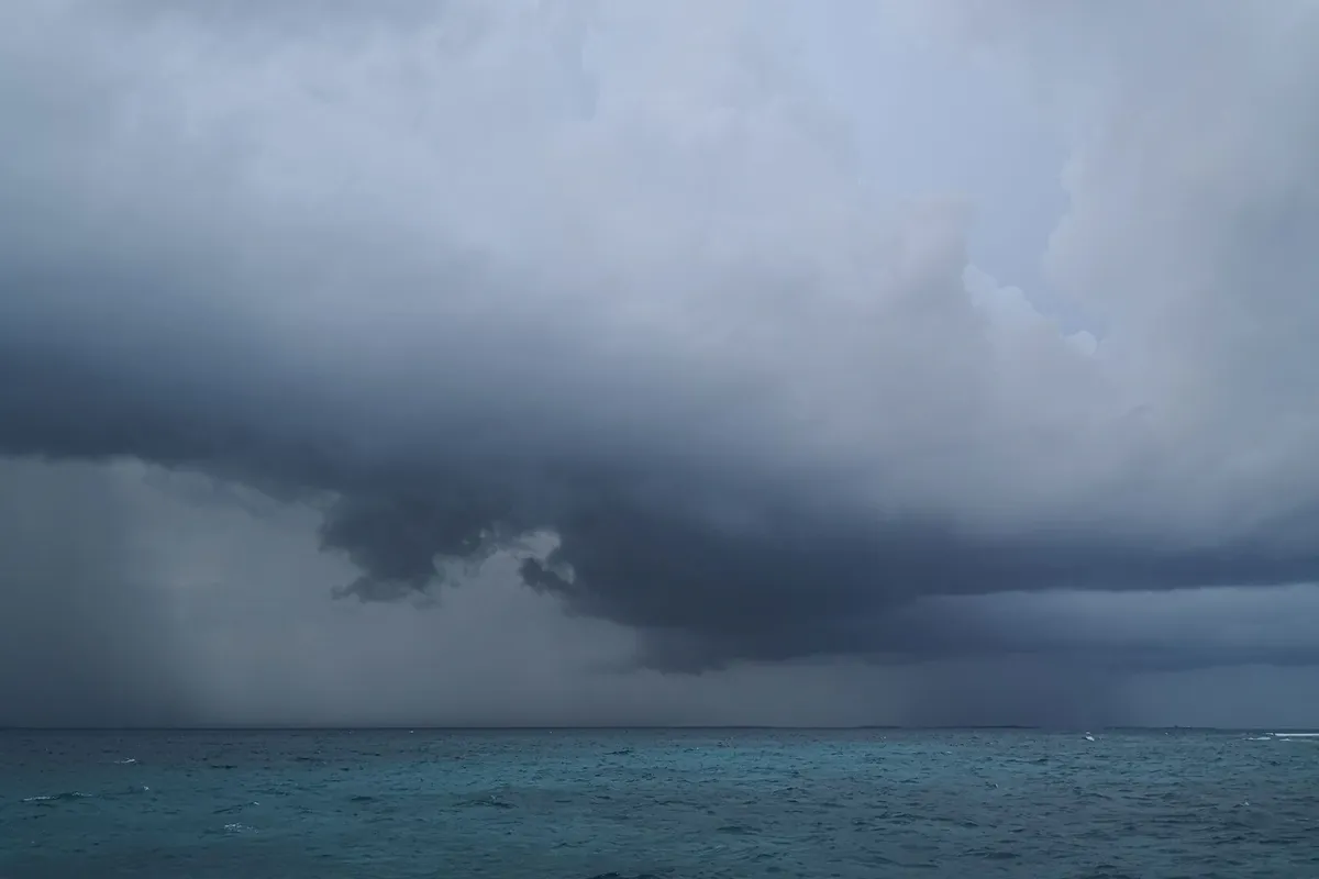 عاصفة مطرية تحت غيوم داكنة فوق البحر المفتوح في جزر المالديف