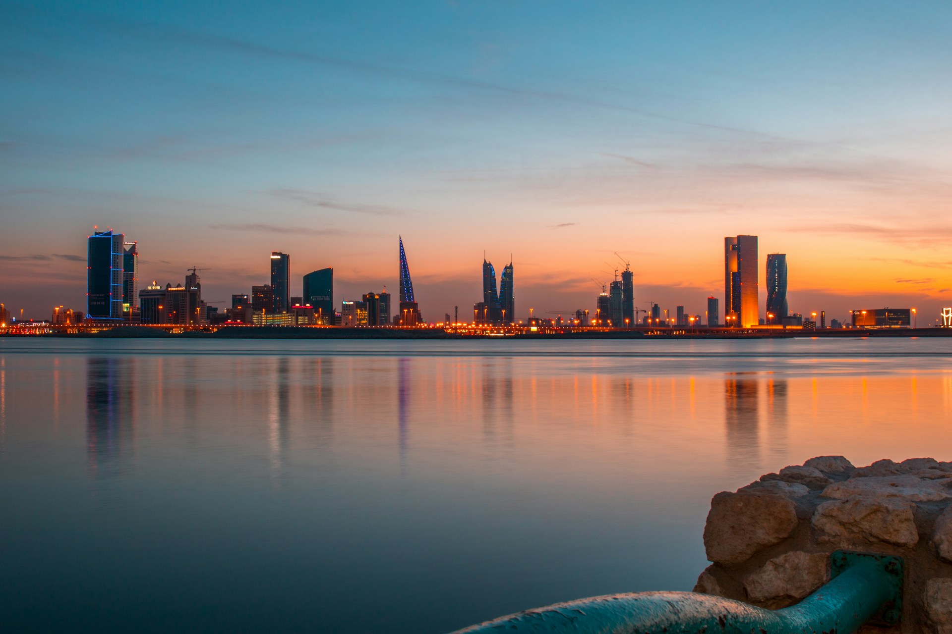 Skyline de la ciudad de Manama con torres modernas y barcos dhow tradicionales en la costa del Golfo Arábigo