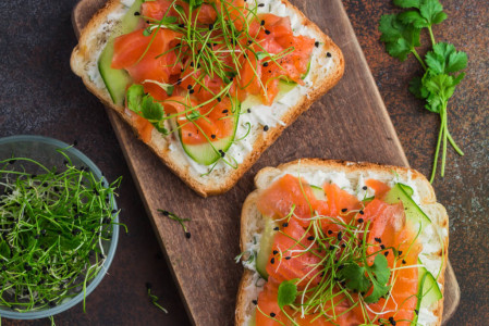 Fresh salmon and brown cheese brunost on a Norwegian breakfast table with rye bread