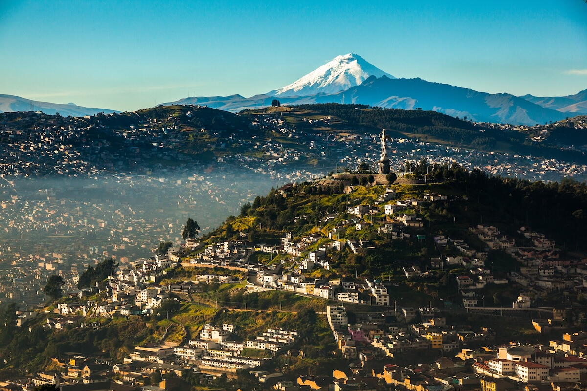 Quitos koloniale Altstadt-Silhouette mit der Basílica del Voto Nacional und dem Pichincha-Vulkan dahinter