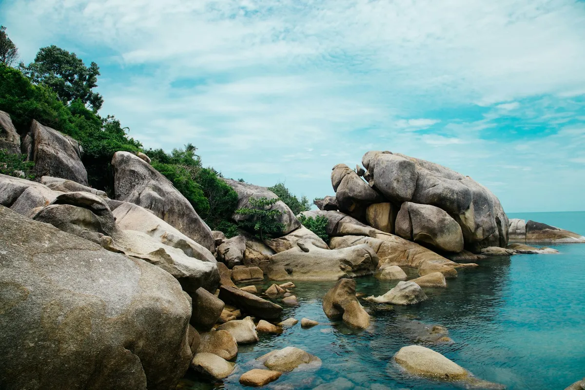 Granitfelsen und eine ruhige türkisfarbene Bucht an der Küste von Koh Samui