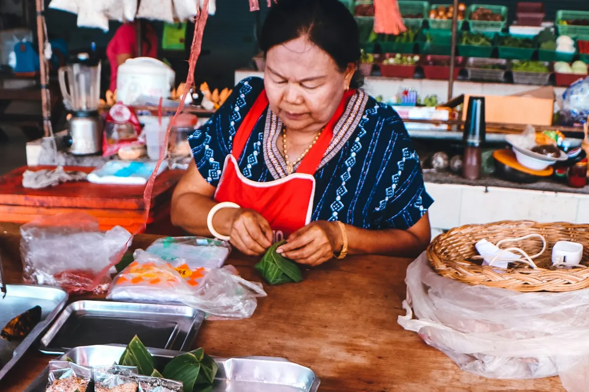 Verkäufer bereitet Essen an einem Marktstand auf Koh Samui zu