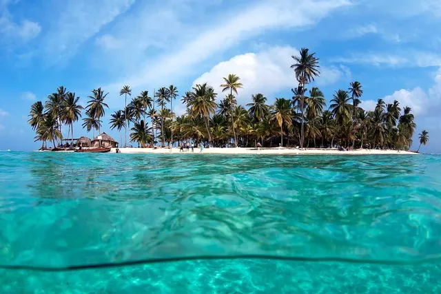 Kleine palmenbedeckte Insel umgeben von türkisfarbenem Wasser auf den San-Blas-Inseln, Guna Yala, Panama