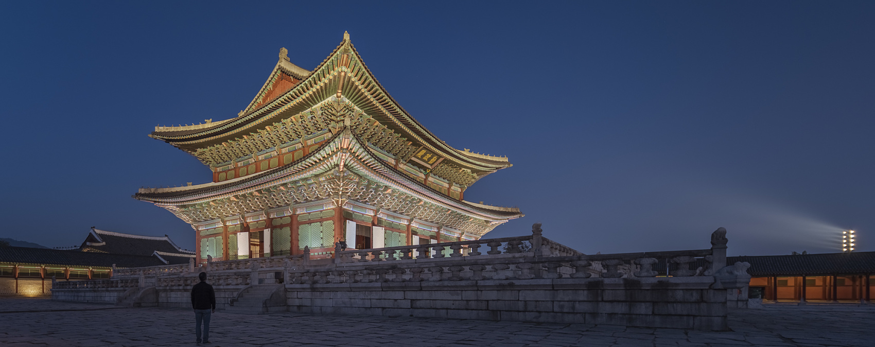 Gyeongbokgung Palace with Seoul's modern skyline behind it at golden hour
