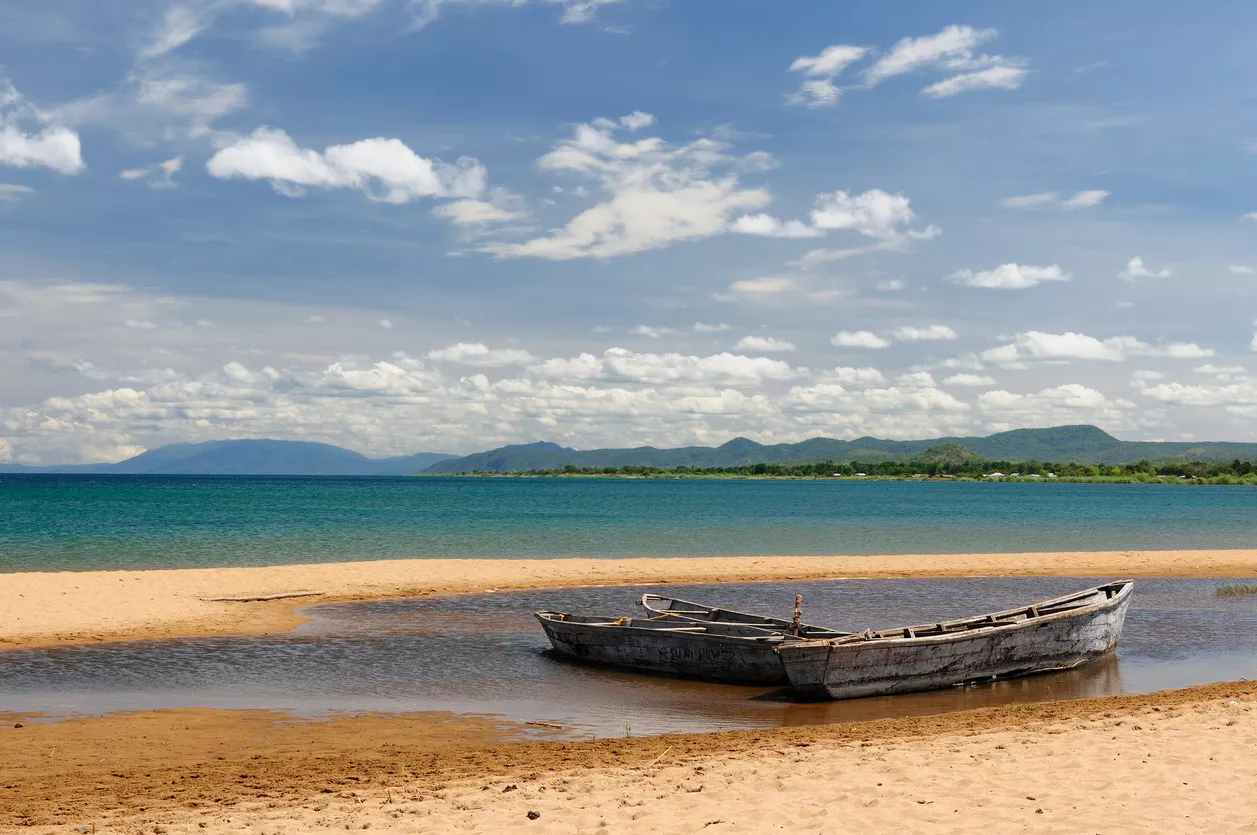Água clara e barcos de pesca ao longo da margem norte do Lago Tanganica perto de Bujumbura, Burundi