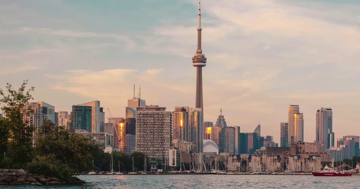 Toronto Skyline mit dem CN Tower über der Hafenpromenade zur goldenen Stunde